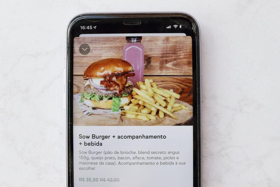 Tela de celular com um cardápio online exibindo um promoção de combo com hambúrguer com suco e batatas fritas.