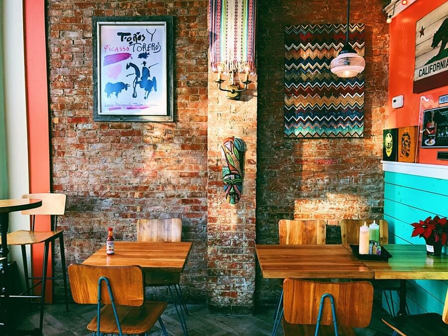 Restaurante temático com duas mesas e cadeiras e decoração na parede.
